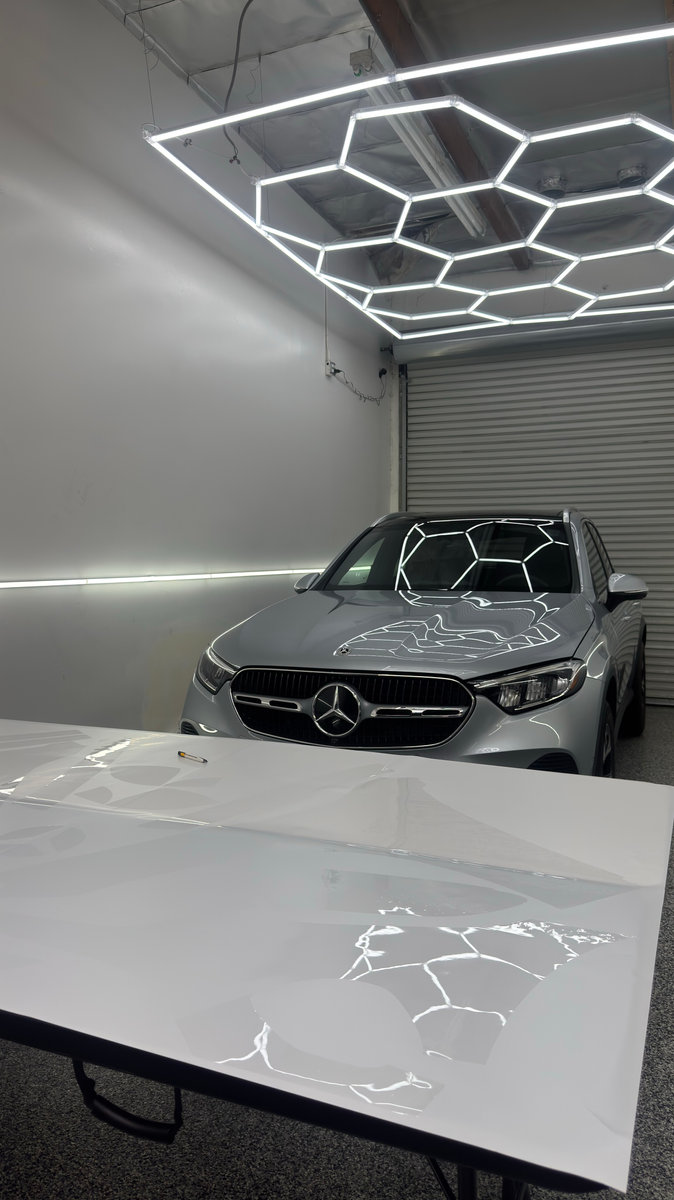 A silver vehicle under the studio’s geometric detailing lights